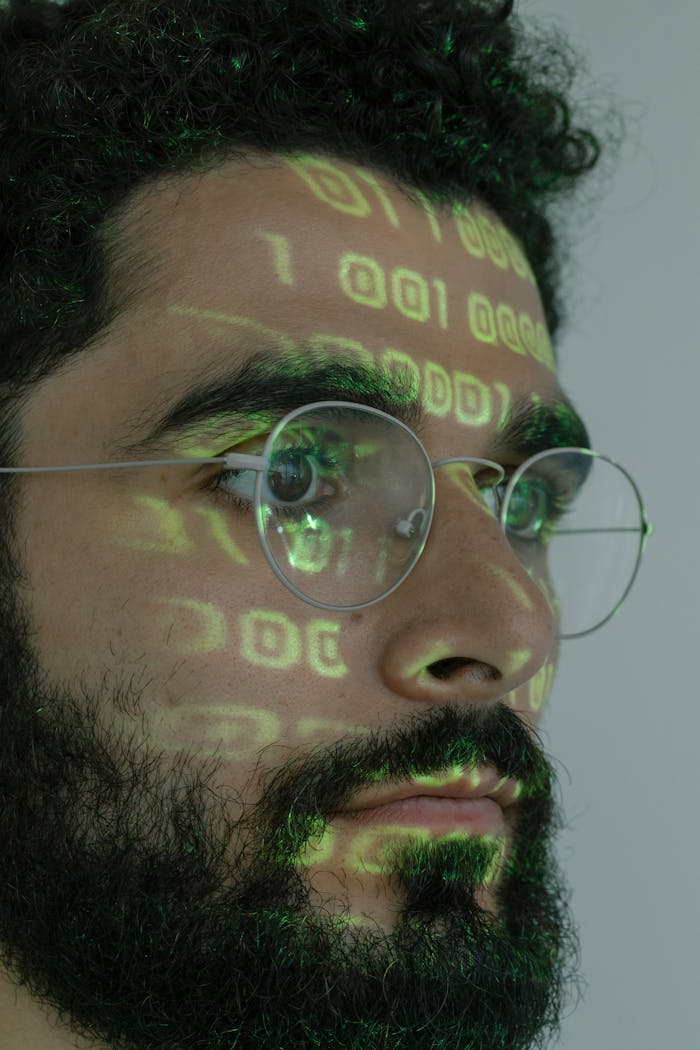 services-01 Close-up of a man with binary code projection reflecting digital identity.